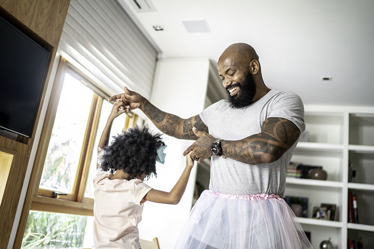 father dancing with daughter after having tlif surgery which is one of dr. justin kubeck's specialty areas